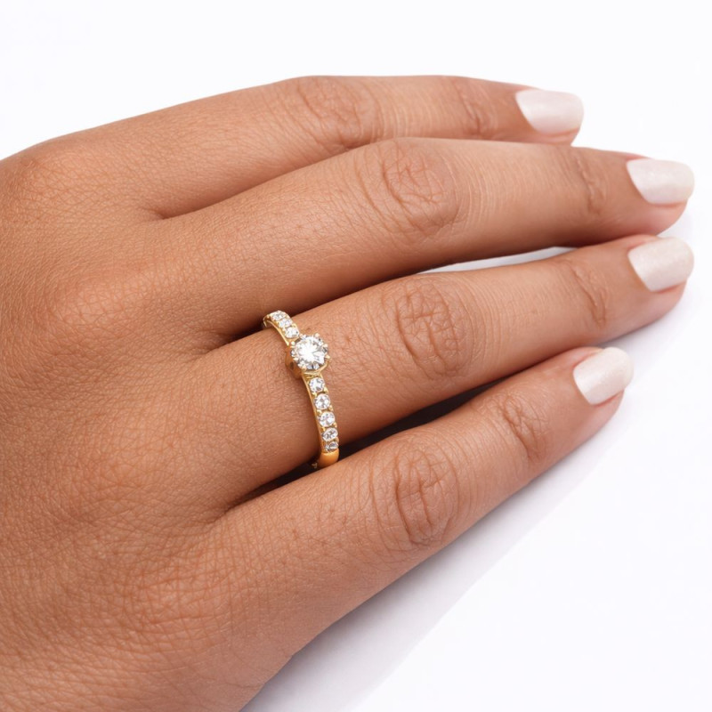 Anillo de oro con diamantes puesto en la mano