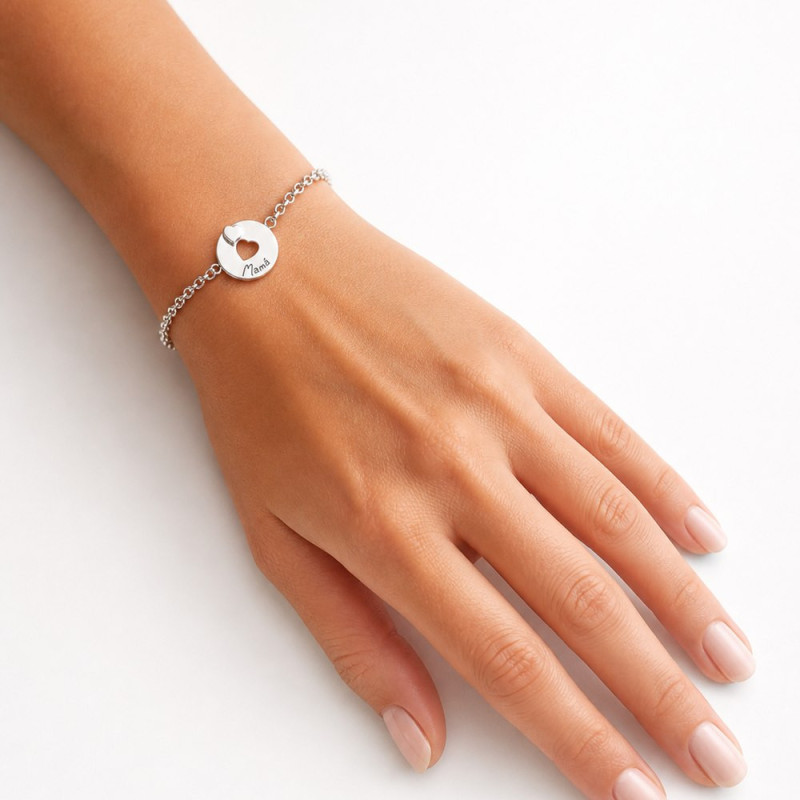 Pulsera de plata con medalla de corazón en la muñeca