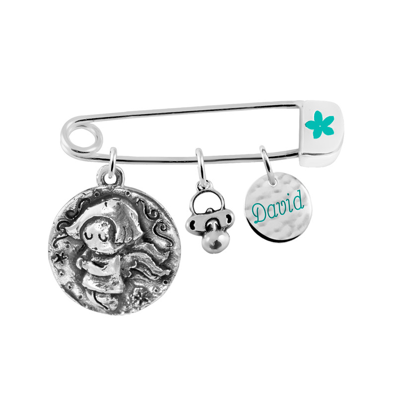safety pin with two medals and a charm