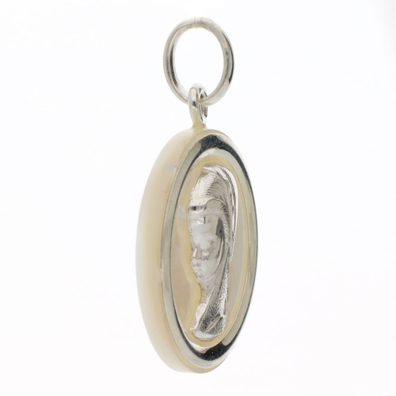 colgante hecho de plata con la silueta de la virgen